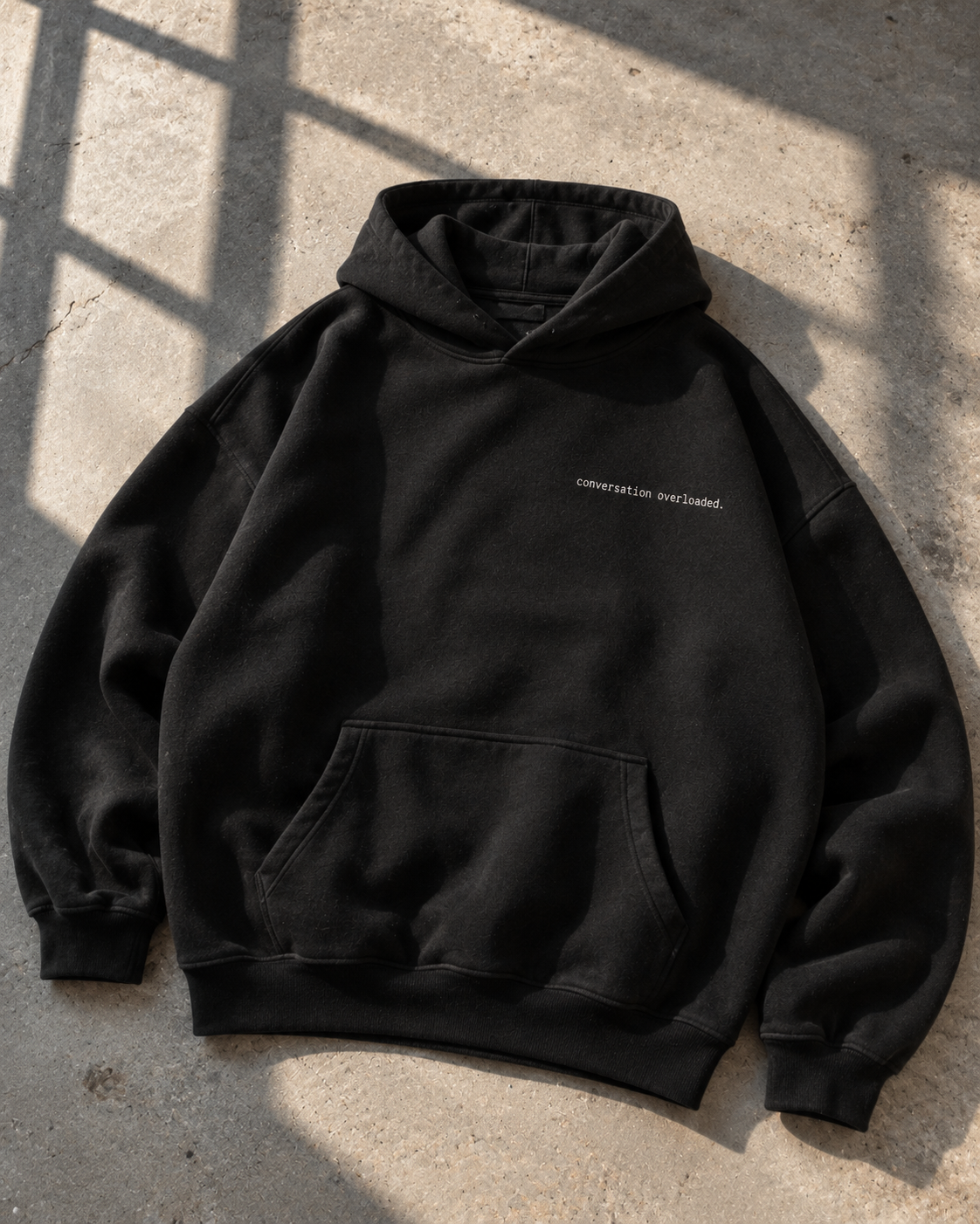 Black heavyweight hoodie front with small conversation overloaded chest print