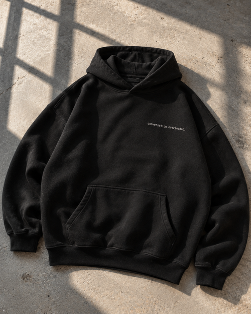 Black heavyweight hoodie front with small conversation overloaded chest print